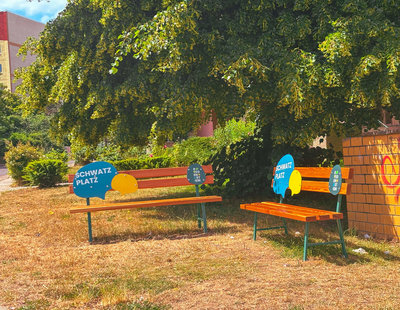zwei freundlich gestaltete Bänke stehen über Eck und bilden einen Schwatzplatz im Quartier Regenstein.