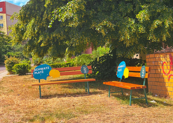 zwei freundlich gestaltete Bänke stehen über Eck und bilden einen Schwatzplatz im Quartier Regenstein.